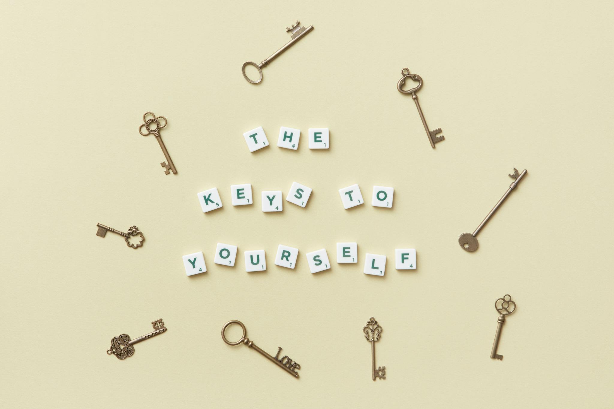Motivational message with antique keys and letter blocks on yellow background.